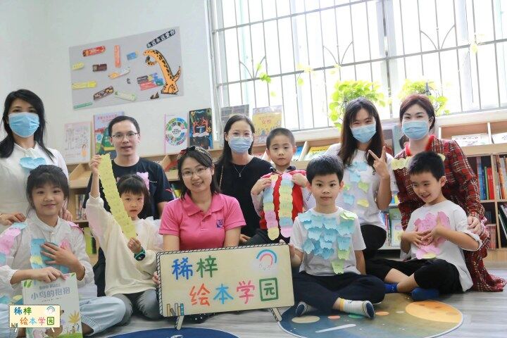 高级绘本讲师零稀梓（前中）和家长孩子们一起悦读绘本。