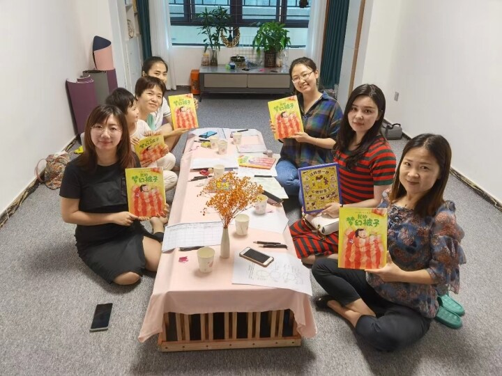 高级绘本讲师零稀梓（右最后）和家长一起悦读绘本。