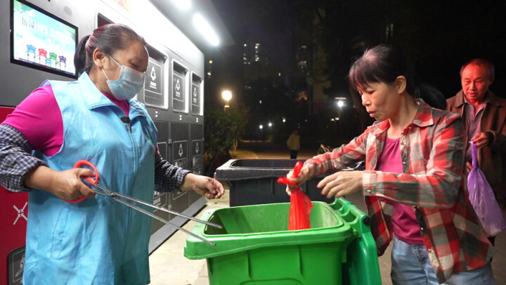 保洁员桶边值守引导业主分类投放垃圾。 保洁员桶边值守引导业主分类投放垃圾。